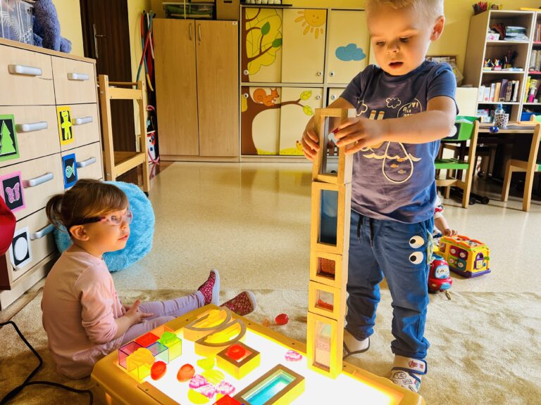 Dzieci bawiące się na sensorycznym panelu podświetlanym