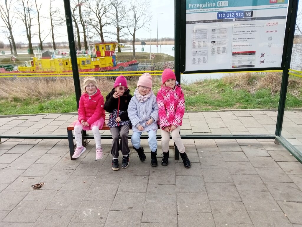 Grupa Promyczków siedząca na przystanku