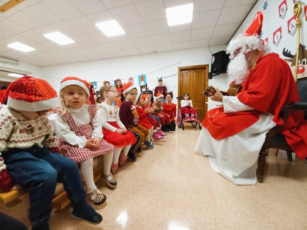 św.Mikołaj śpiewa i gra na gitarze kolędy