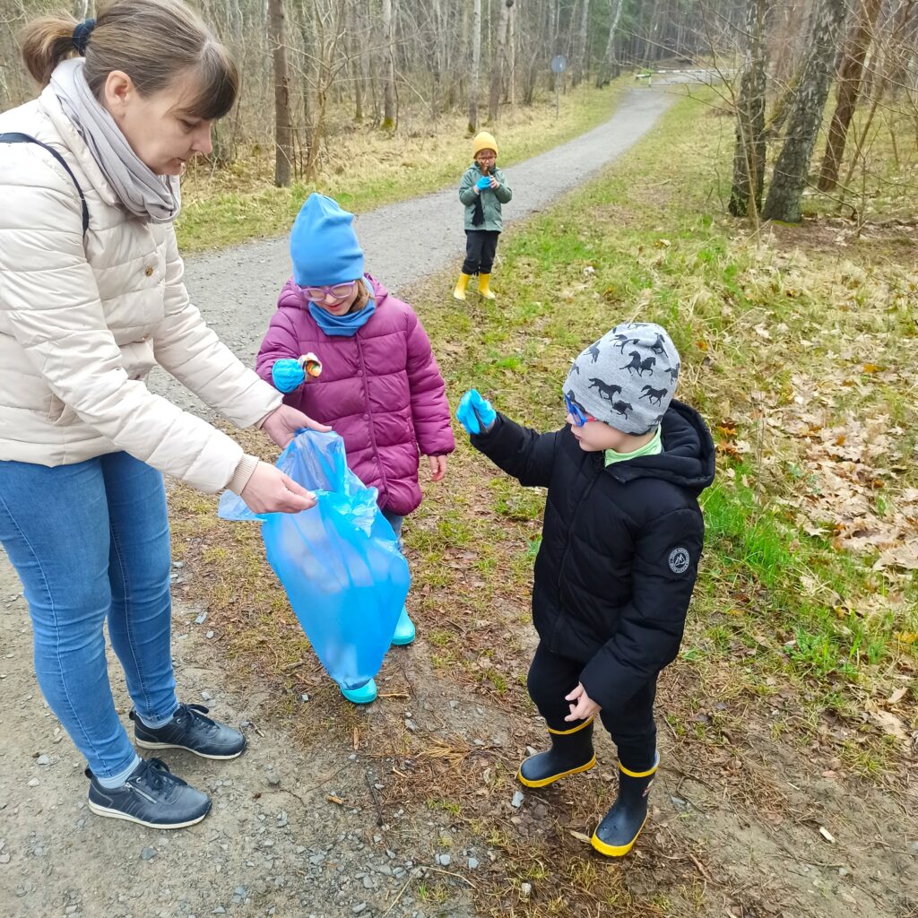 Julia i Szymon wrzucają śmieci do worka 