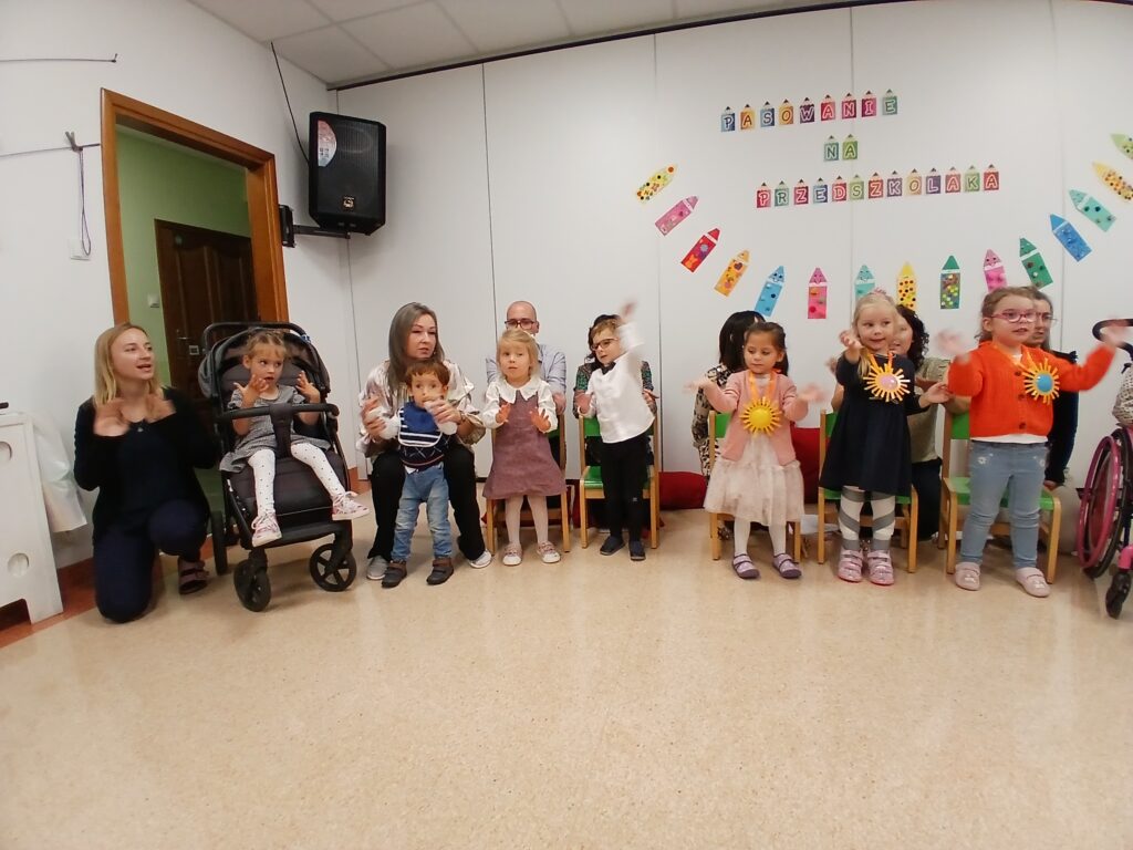 Dzieci na przedstawieniu machają do rodziców