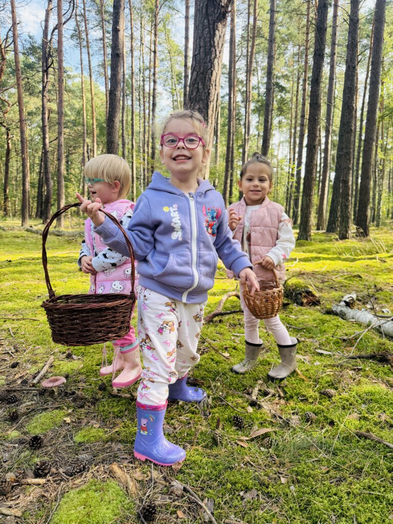 Dziewczynki chodzące po lesie z koszykami na grzyby